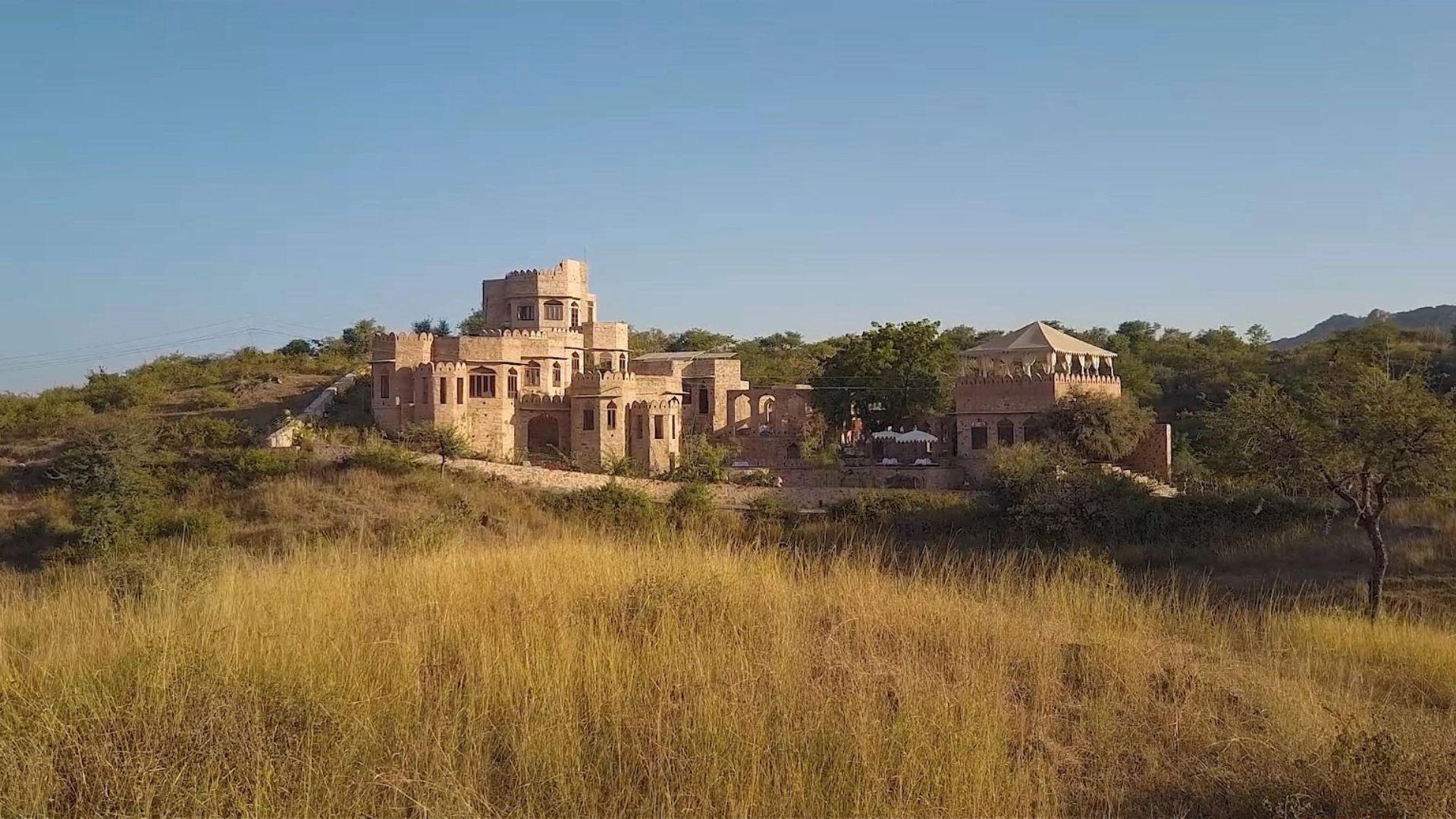 Raht Manmatha fort estate in daylight among Aravalli scrub and grassland, Udaipur, Rajasthan